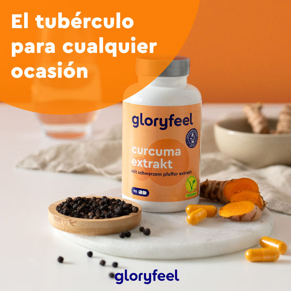 Frasco GloryFeel Extracto de cúrcuma en cápsulas, con trozos de cúrcuma orgánica y granos de pimienta negra sobre superficie blanca. Texto en español: "El tubérculo para cualquier ocasión". Con ingredientes de alta calidad sobre un fondo naranja.