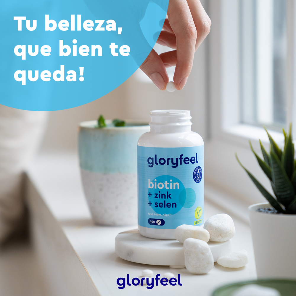 Una mano alcanza un frasco de Biotina en tabletas de GloryFeel GmbH España en el alféizar de una ventana, rodeado de plantas y piedras. El texto dice &quot;¡Tu belleza, que bien te queda!&quot;. Mejora la salud de tu cabello de forma natural.