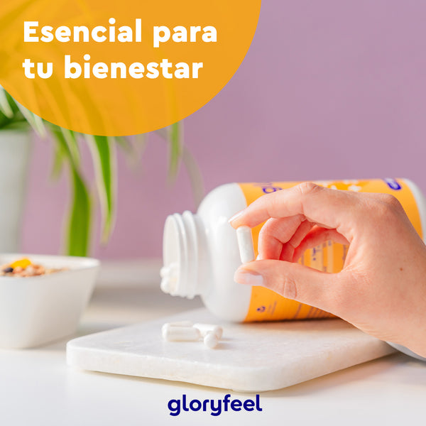 Una mano sostiene una cápsula blanca sobre una botella derramada sobre una mesa, promoviendo &quot;tu sistema inmunitario&quot;. El texto dice &quot;Esencial para tu bienestar&quot; con &quot;Gloryfeel GmbH&quot; en la parte inferior. Un recipiente y una planta al fondo. Producto: L-lisina con zinc.