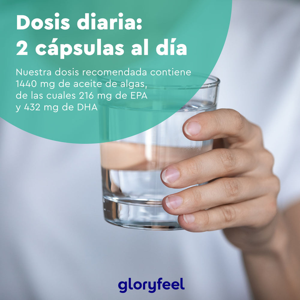 Una persona sostiene un vaso de agua junto a un texto que indica una dosis diaria de dos cápsulas, que juntas contienen 1440 mg de aceite de algas rico en Omega 3 (EPA y DHA), de GloryFeel GmbH España &quot;Omega 3 Vegano en cápsulas&quot;.