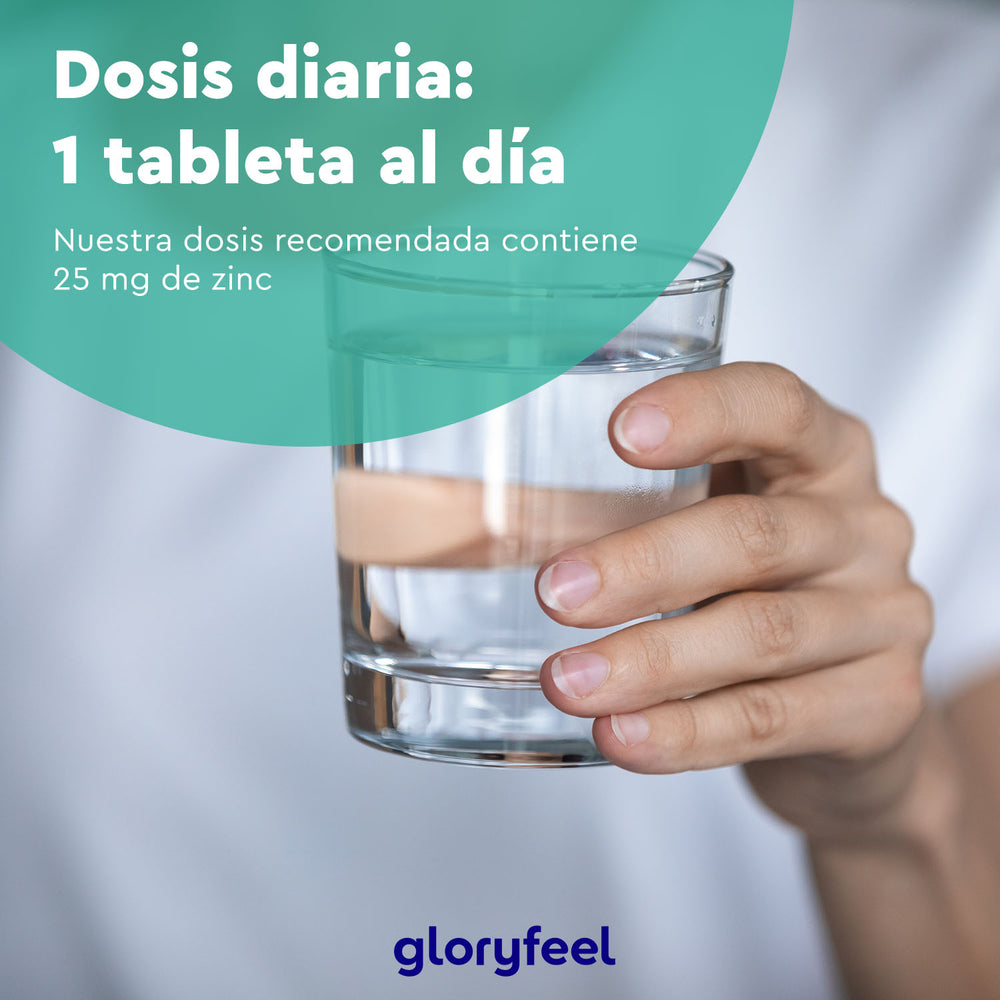 Una mano sostiene un vaso de agua. Texto en la imagen: &quot;Dosis diaria: 1 tableta al día. Zinc 25 mg en tabletas de GloryFeel GmbH Spain para apoyar el metabolismo de las proteínas.