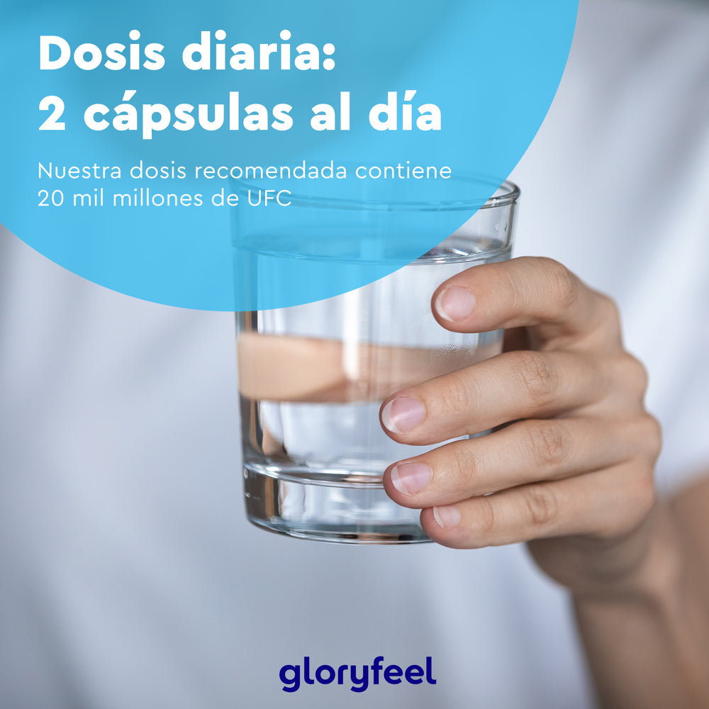 Una mano sostiene un vaso de agua con un texto en español que recomienda una dosis diaria de 2 cápsulas con 20 mil millones de UFC para el mantenimiento de la flora intestinal. En la parte inferior se lee &quot;GloryFeel GmbH España&quot;.