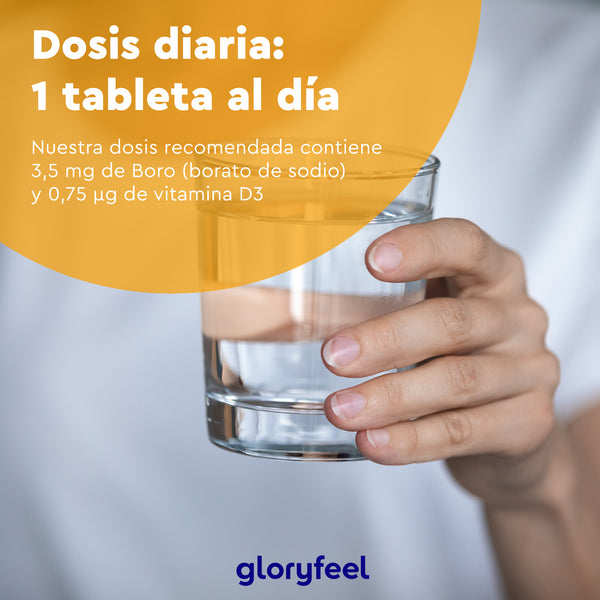 Una mano sostiene un vaso de agua contra un fondo borroso, con un texto en español que muestra la dosis diaria en tabletas de &quot;Boro con Vitamina D3&quot;, resaltando el contenido de boro y vitamina D3 de Gloryfeel GmbH.