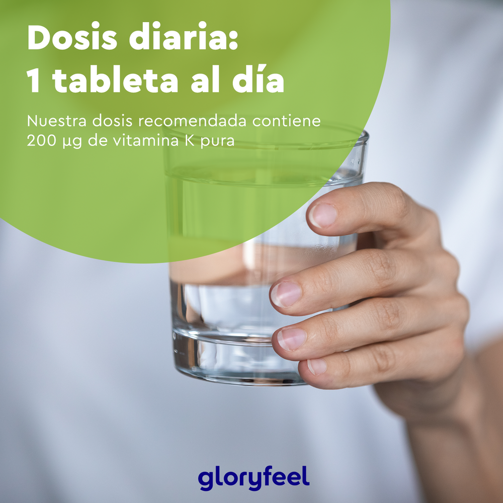 Una mano sostiene un vaso de agua junto a un círculo verde con el texto: &quot;Dosis diaria: 1 tableta al día. Nuestra dosis recomendada contiene 200 µg de vitamina K2 (Menaquinona)&quot;. Descubra la pureza de Vitamina K2 en tabletas de Gloryfeel GmbH.