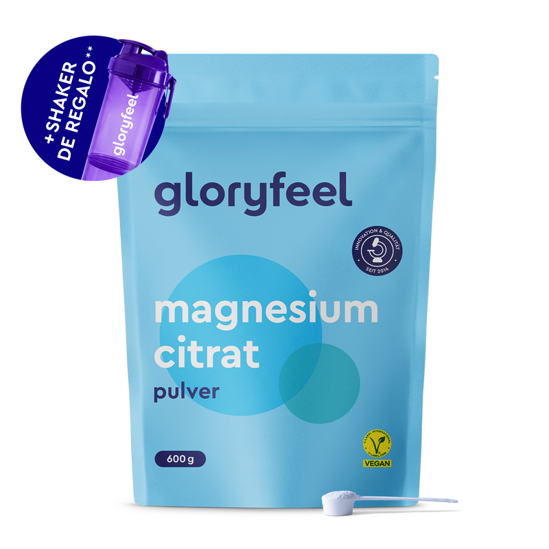 Una bolsita azul de 600 g de "Magnesio en polvo" de gloryfeel GmbH España con un icono vegano y un cacito, además de un agitador morado incluido de regalo.