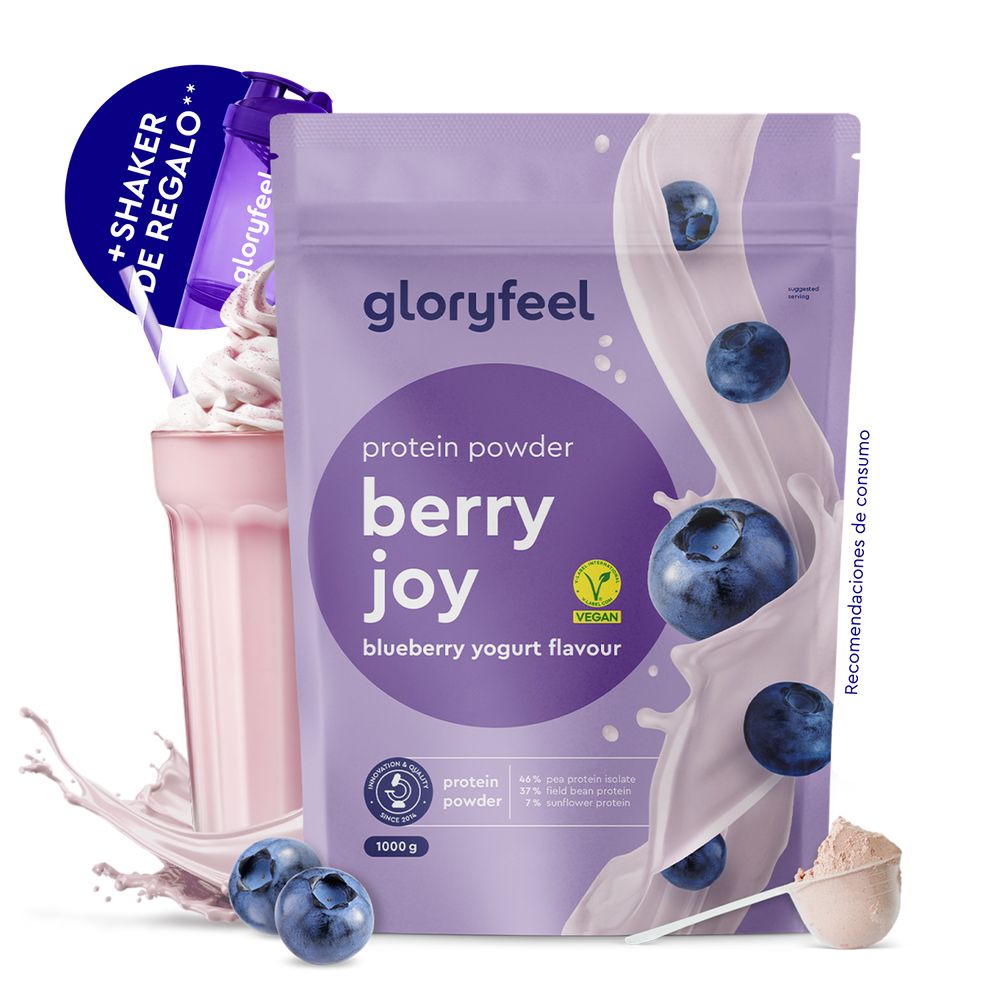 Una bolsa de Proteina Yogur de arándanos de gloryfeel GmbH España, mostrada con arándanos, un vaso de batido, un cacito de polvo y un agitador de regalo.