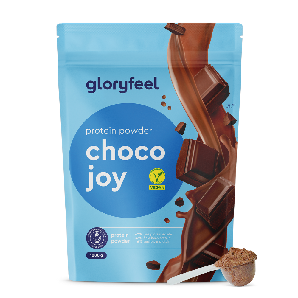 Proteina Choco Joy de gloryfeel GmbH España, presentada con trozos de chocolate y una cuchara para el polvo, también cuenta con una etiqueta vegana.