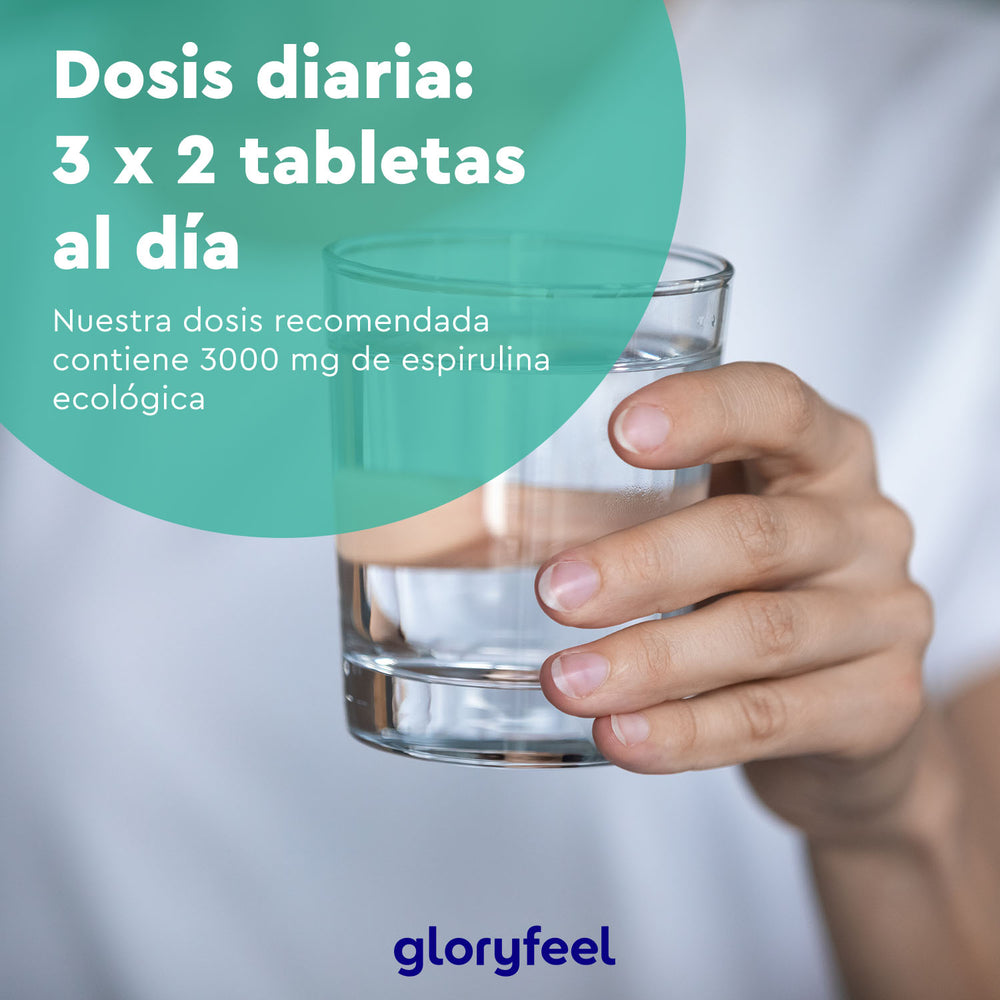 Una mano sostiene un vaso de agua, con un texto sobre una dosis diaria de 3000 mg de Espirulina Ecológica - Tabletas de GloryFeel GmbH España.