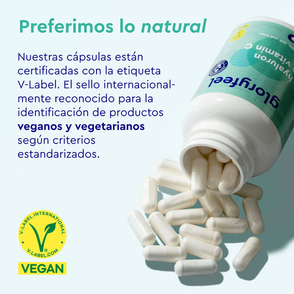 Una botella de «Ácido ialurónico con vitamina C» de gloryfeel GmbH España está volcada, derramando cápsulas blancas sobre una superficie verde. Un texto en español destaca la certificación vegana del producto.
