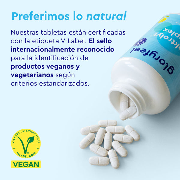 Una botella abierta de Tabletas de Electrolitos de gloryfeel GmbH España con tabletas derramadas sobre un fondo azul claro. Cuenta con la certificación V-Label para productos veganos y vegetarianos.