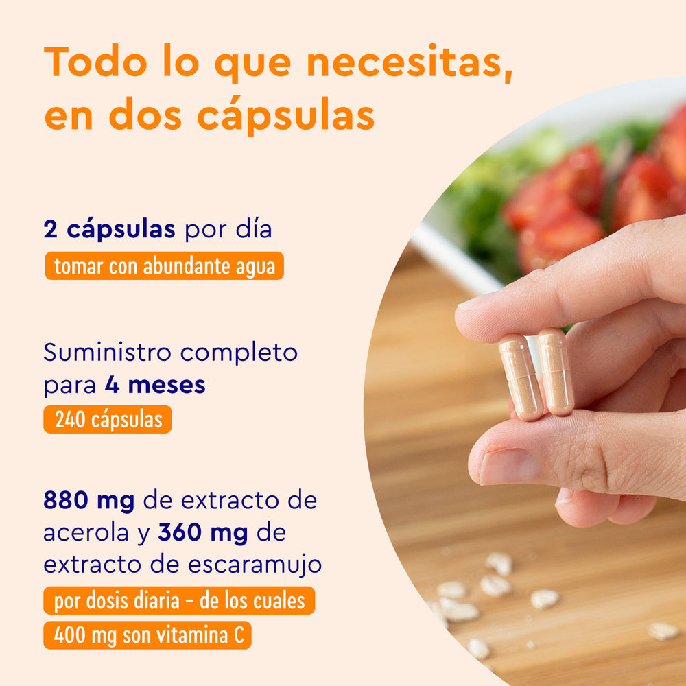 Una mano sostiene dos cápsulas junto a tabletas blancas derramadas, una ensalada y un texto en español sobre la vitamina C natural de GloryFeel GmbH España, la acerola y los beneficios para el sistema inmunológico.
